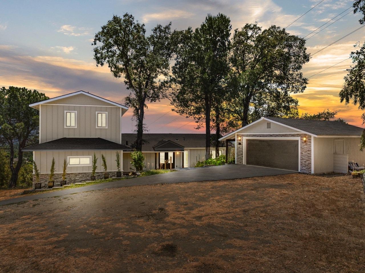 a front view of a house with a yard and trees