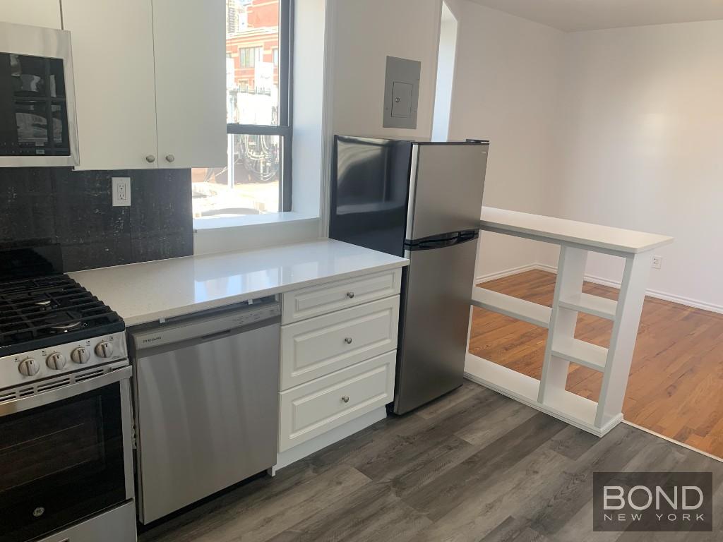 a kitchen with granite countertop a stove and a refrigerator