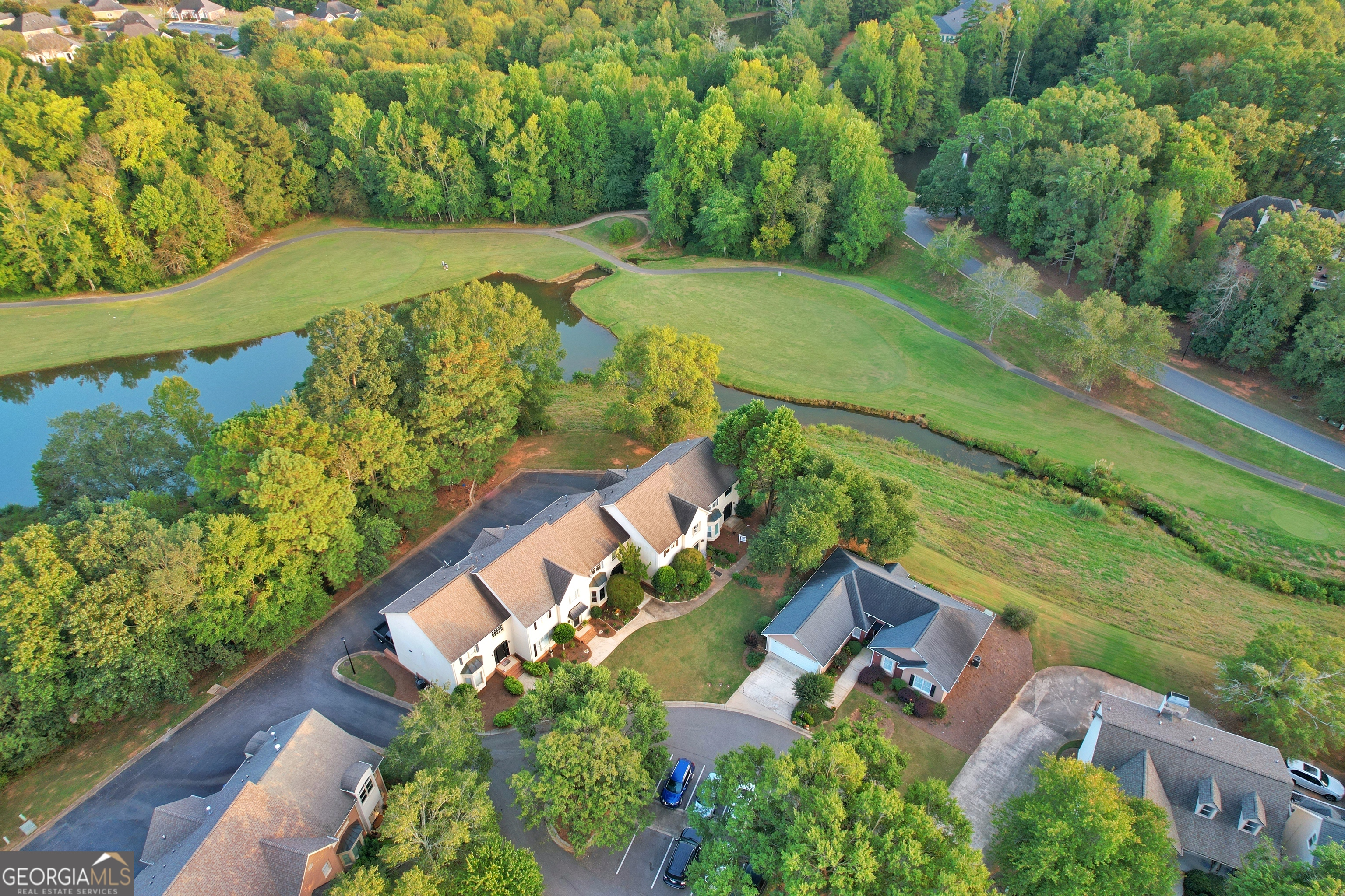 an aerial view of a house with a yard and lake view