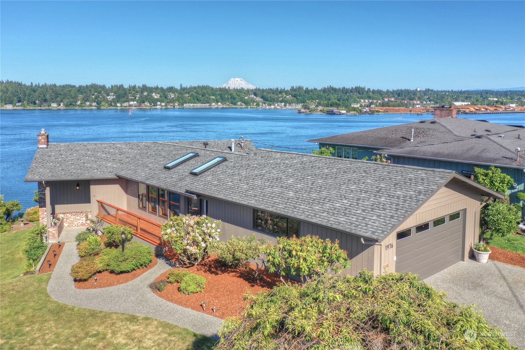 an aerial view of a house with a garden and lake view