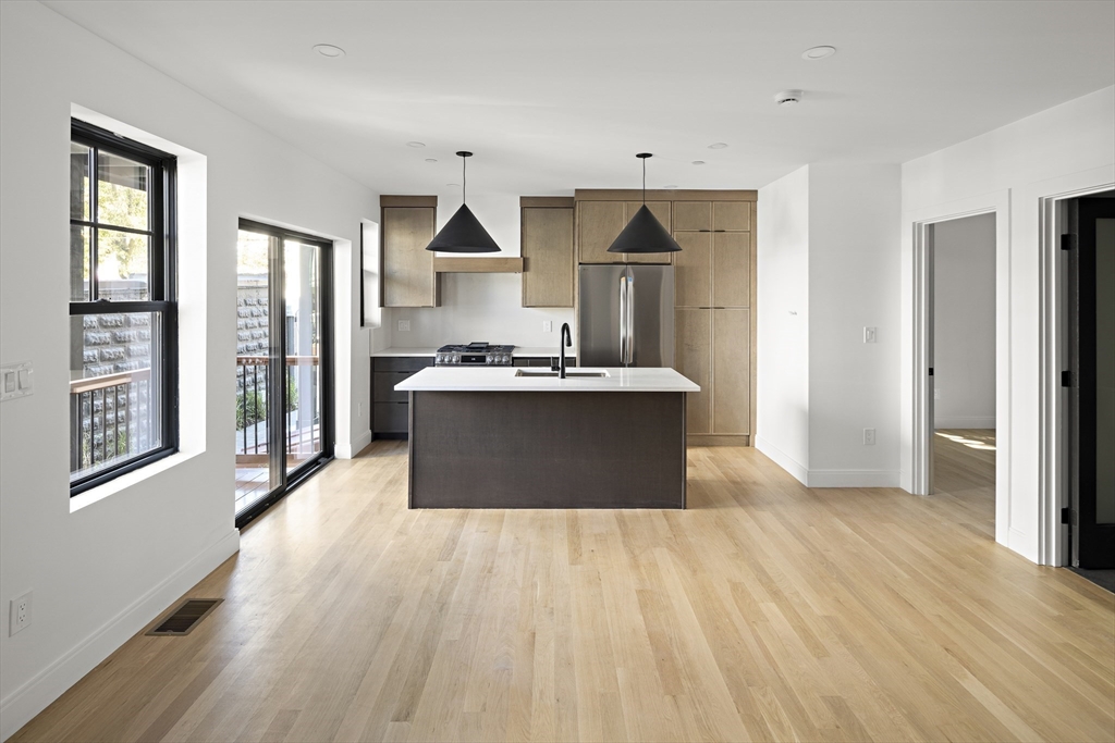 a view of kitchen with wooden floor and electronic appliances