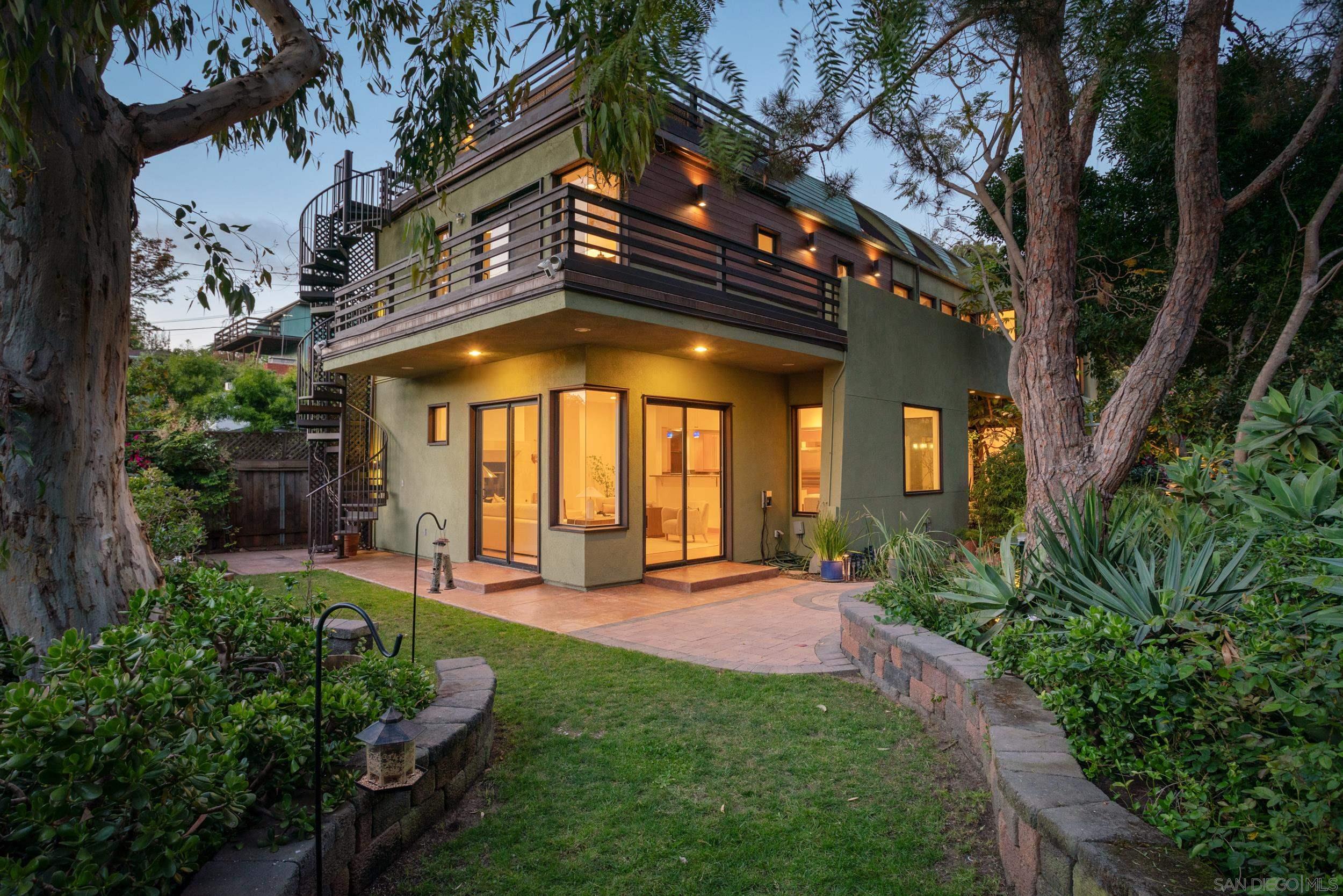 a view of a house with a small yard plants and large tree