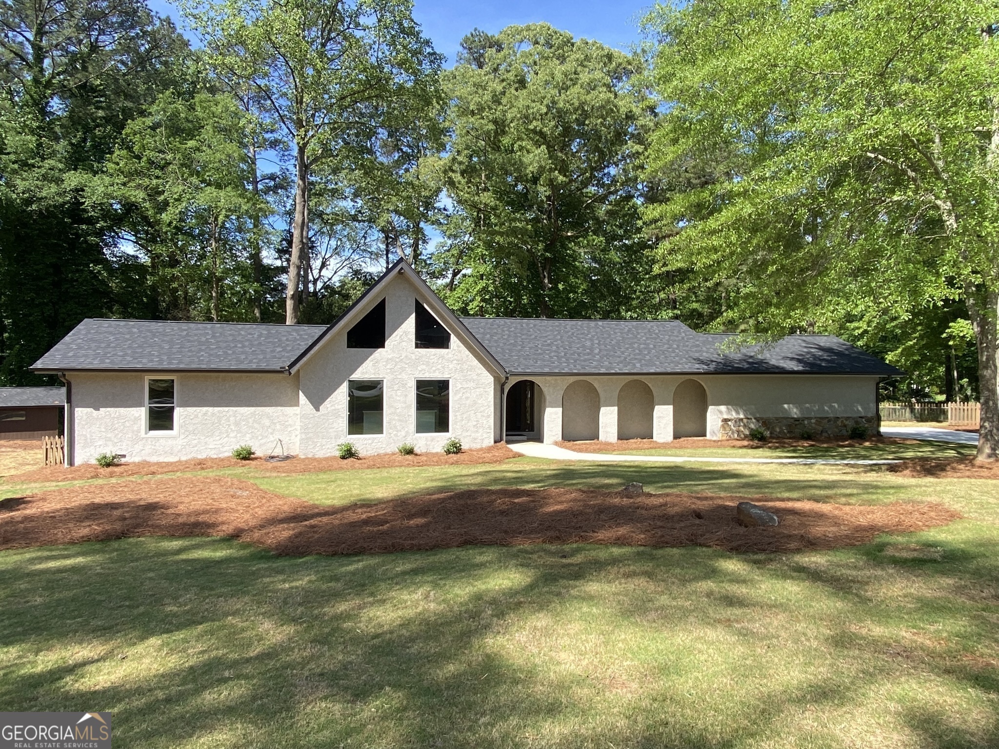 a front view of a house with a yard and trees