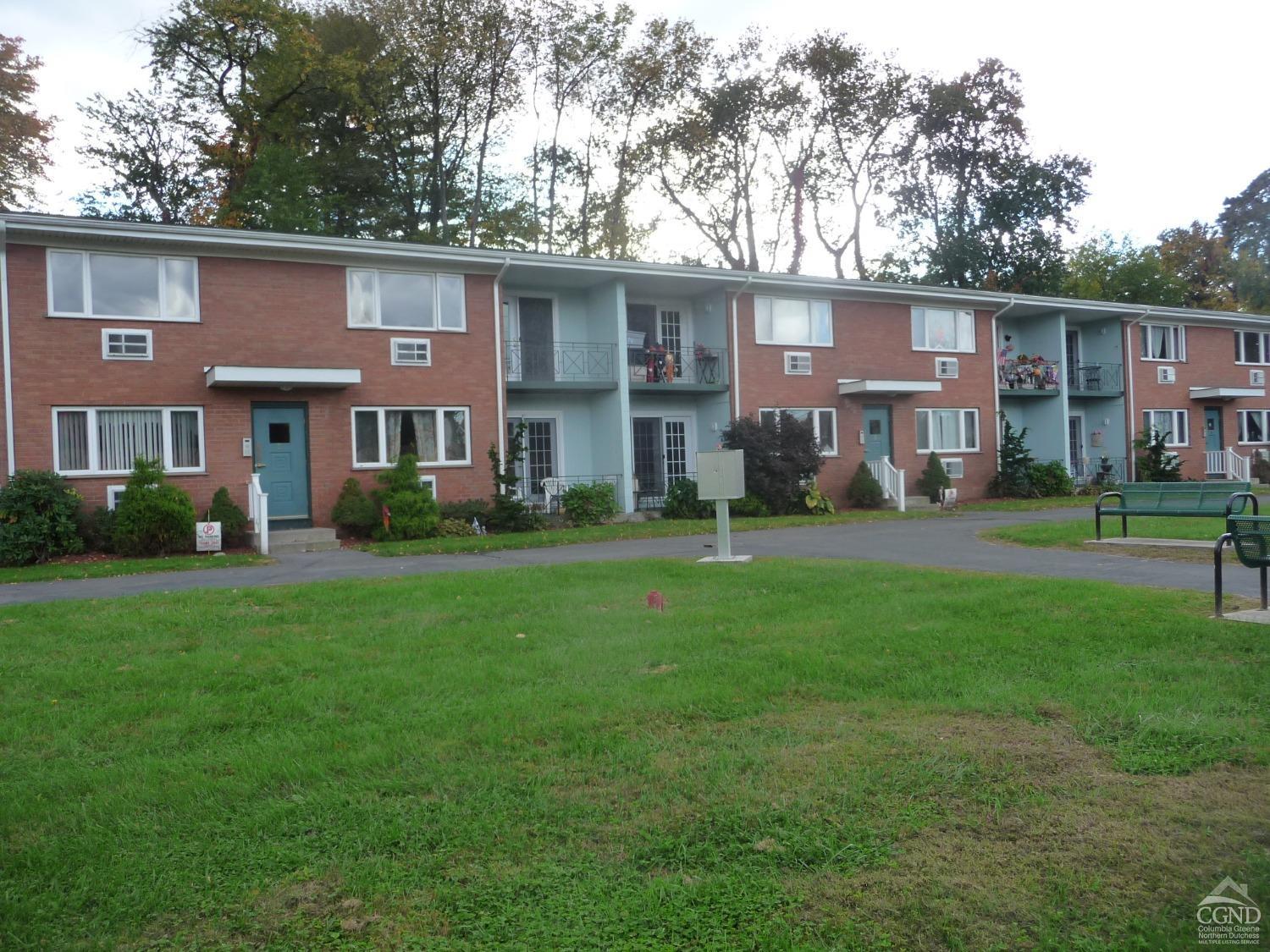 a front view of a house with a yard and trees