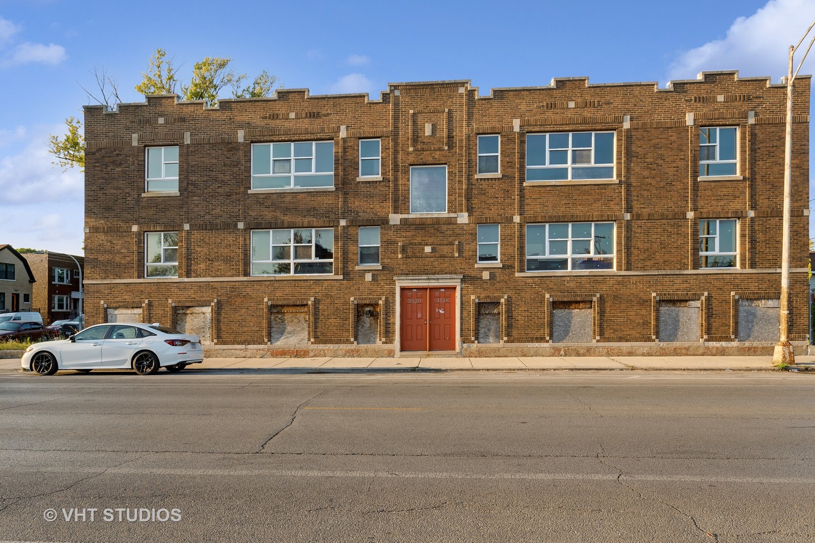 a front view of a building with car parked