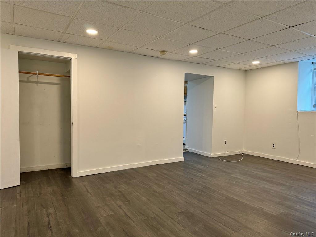 an empty room with wooden floor and closet area