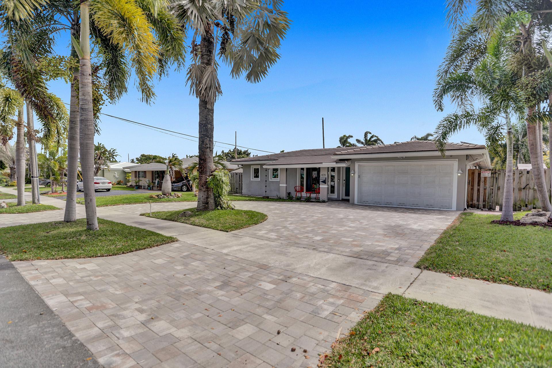 a view of a house with a yard and palm trees