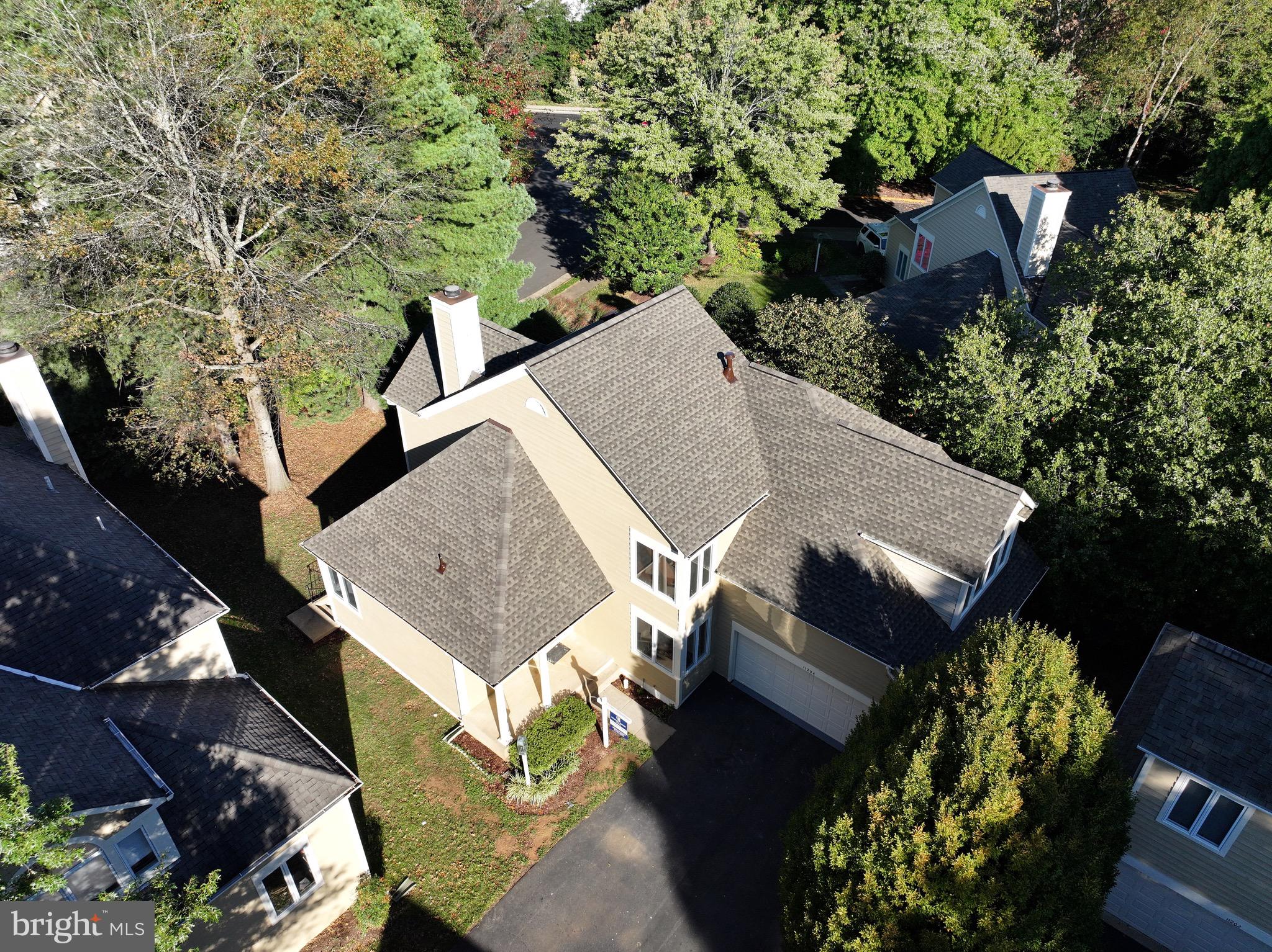 an aerial view of a house with a yard and street