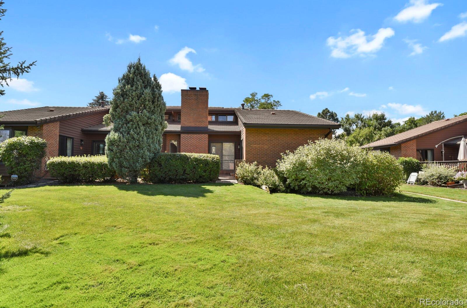 a view of a house with a big yard and potted plants