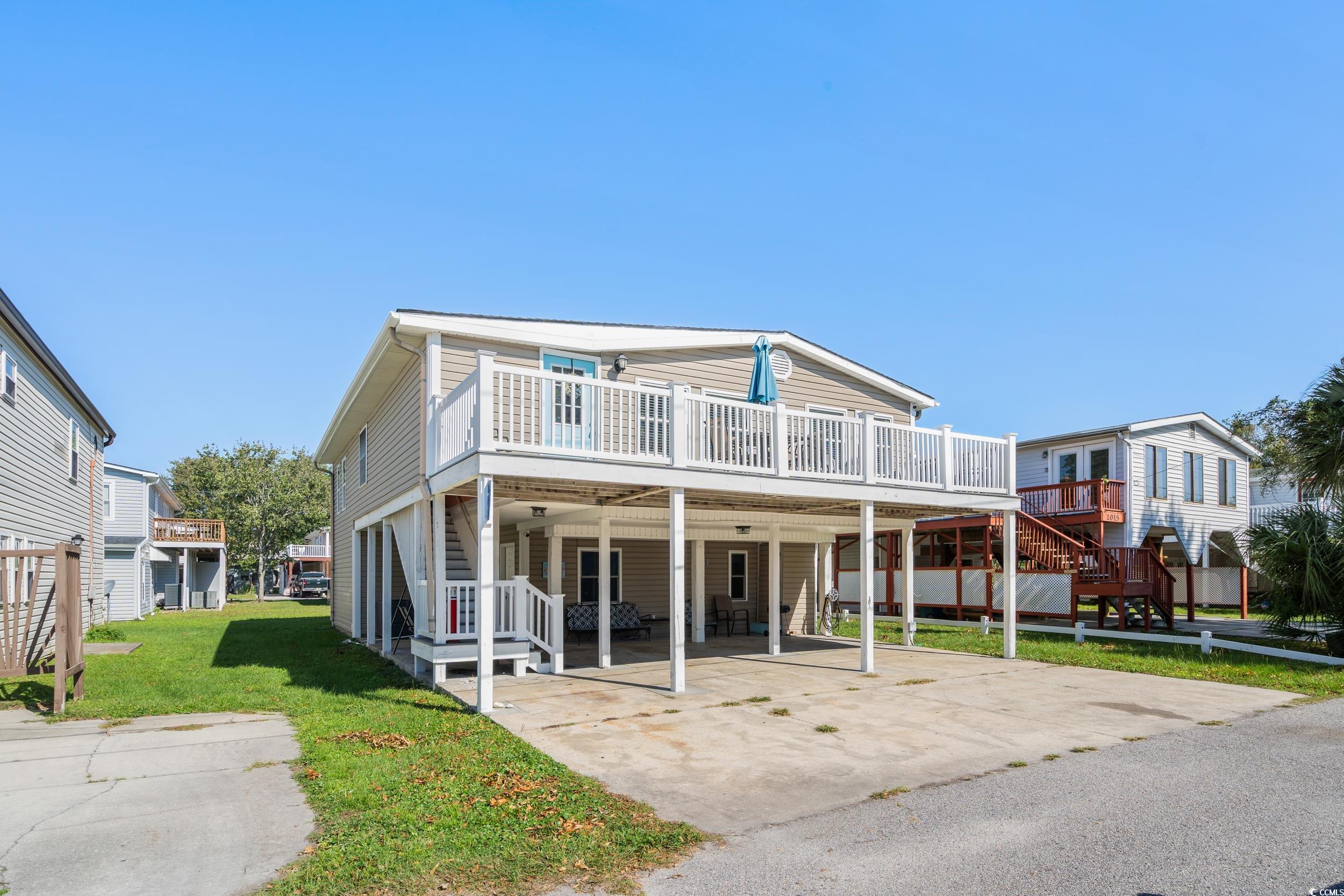 View of front of home with a carport, a front yard