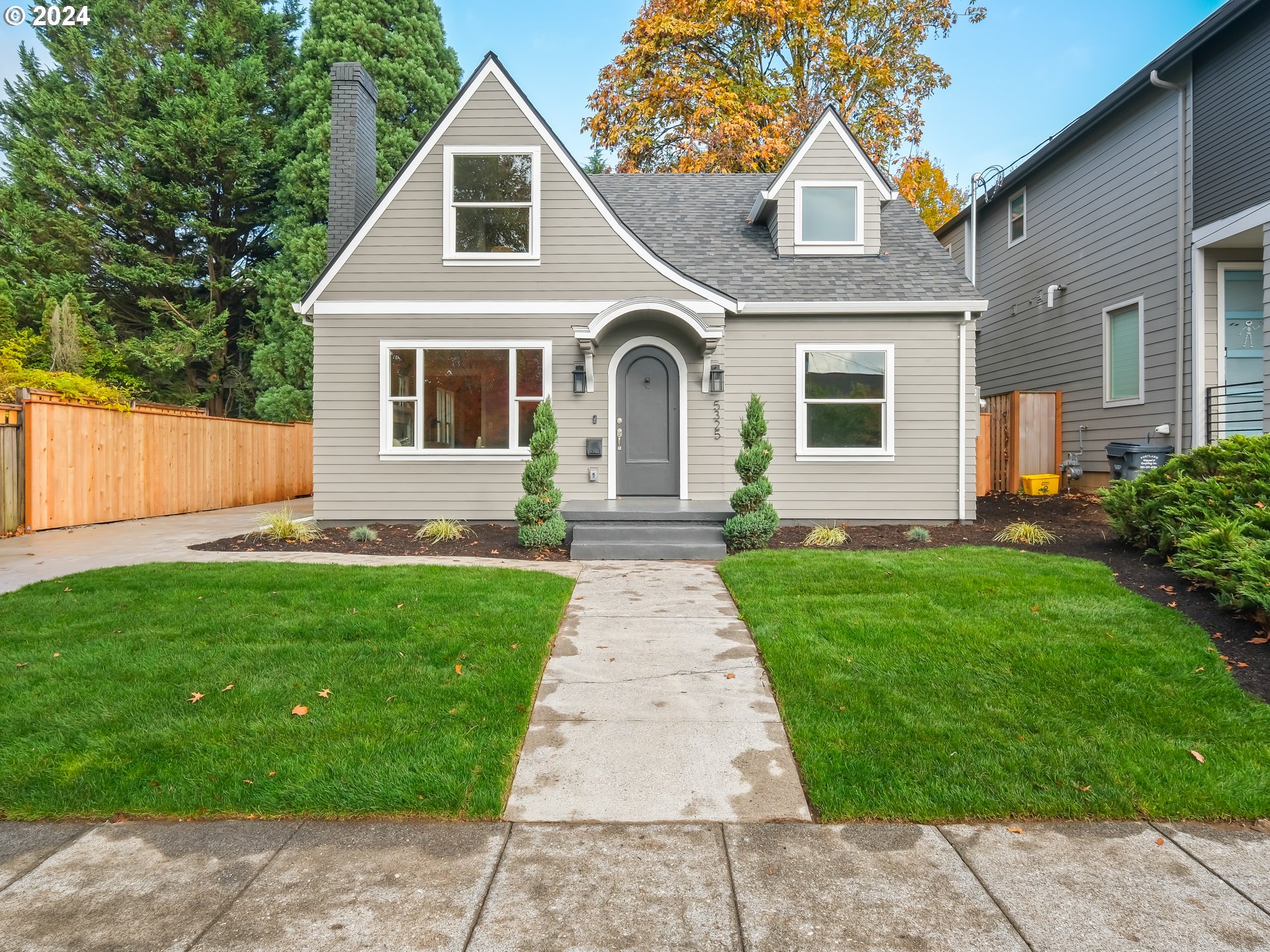 a front view of a house with a garden and yard