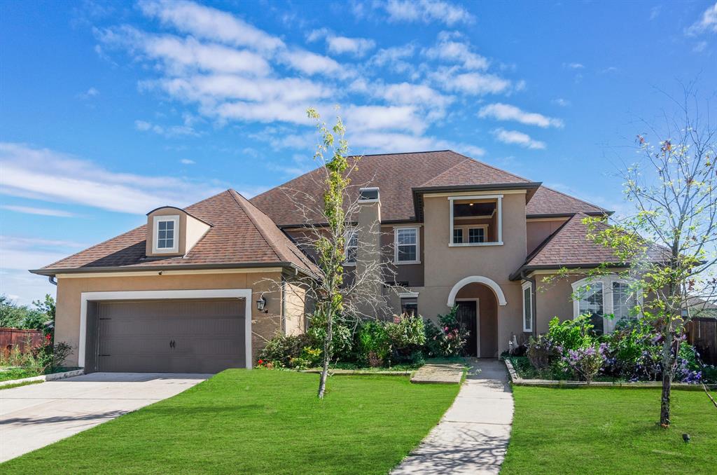 a front view of a house with a garden and yard