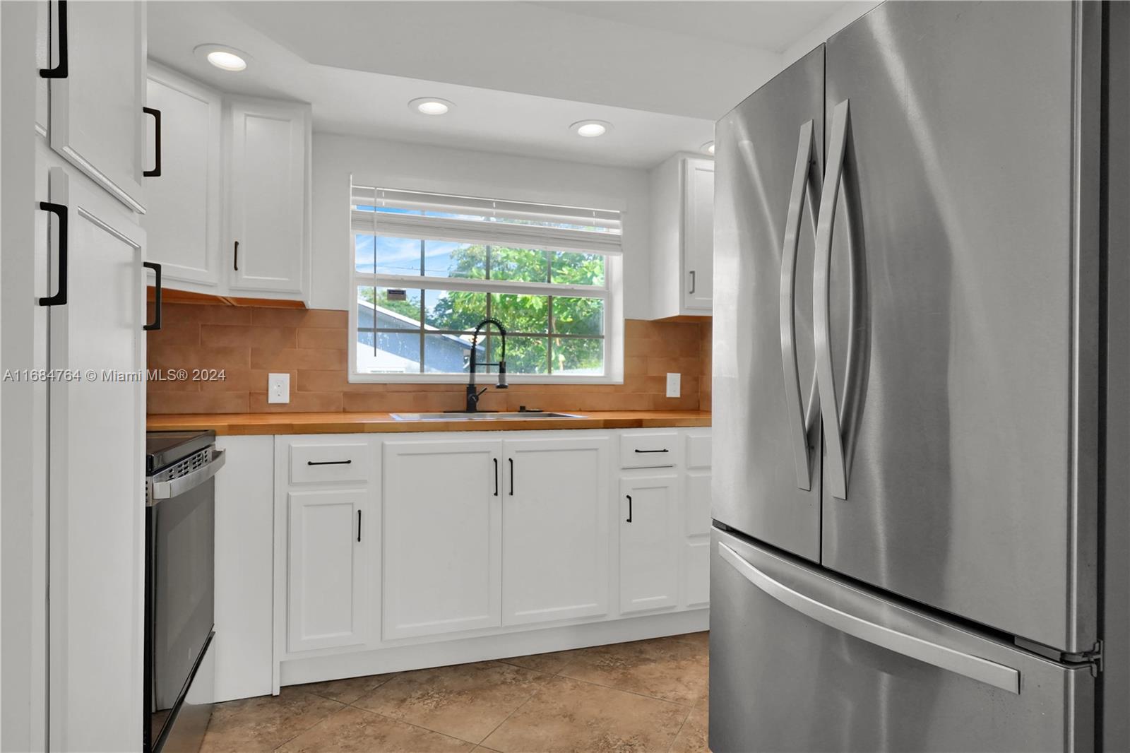 a kitchen with stainless steel appliances a refrigerator sink and cabinets