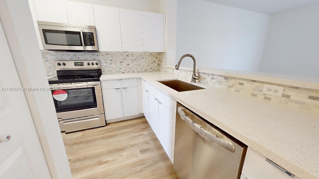 a kitchen with a sink a stove and microwave