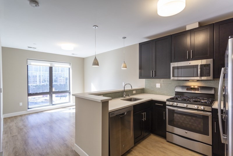 a kitchen with stainless steel appliances a stove a sink and a microwave