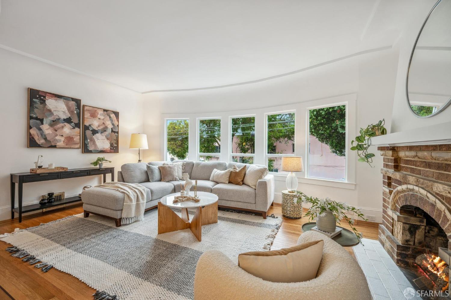 a living room with furniture a fireplace and a large window