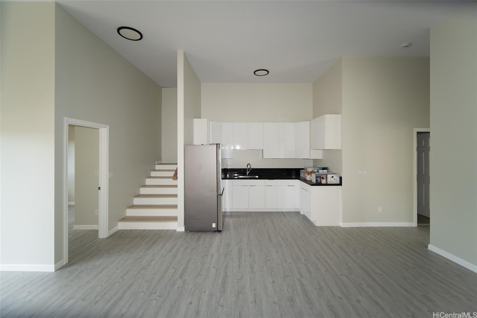 a view of a kitchen with wooden floor and electronic appliances