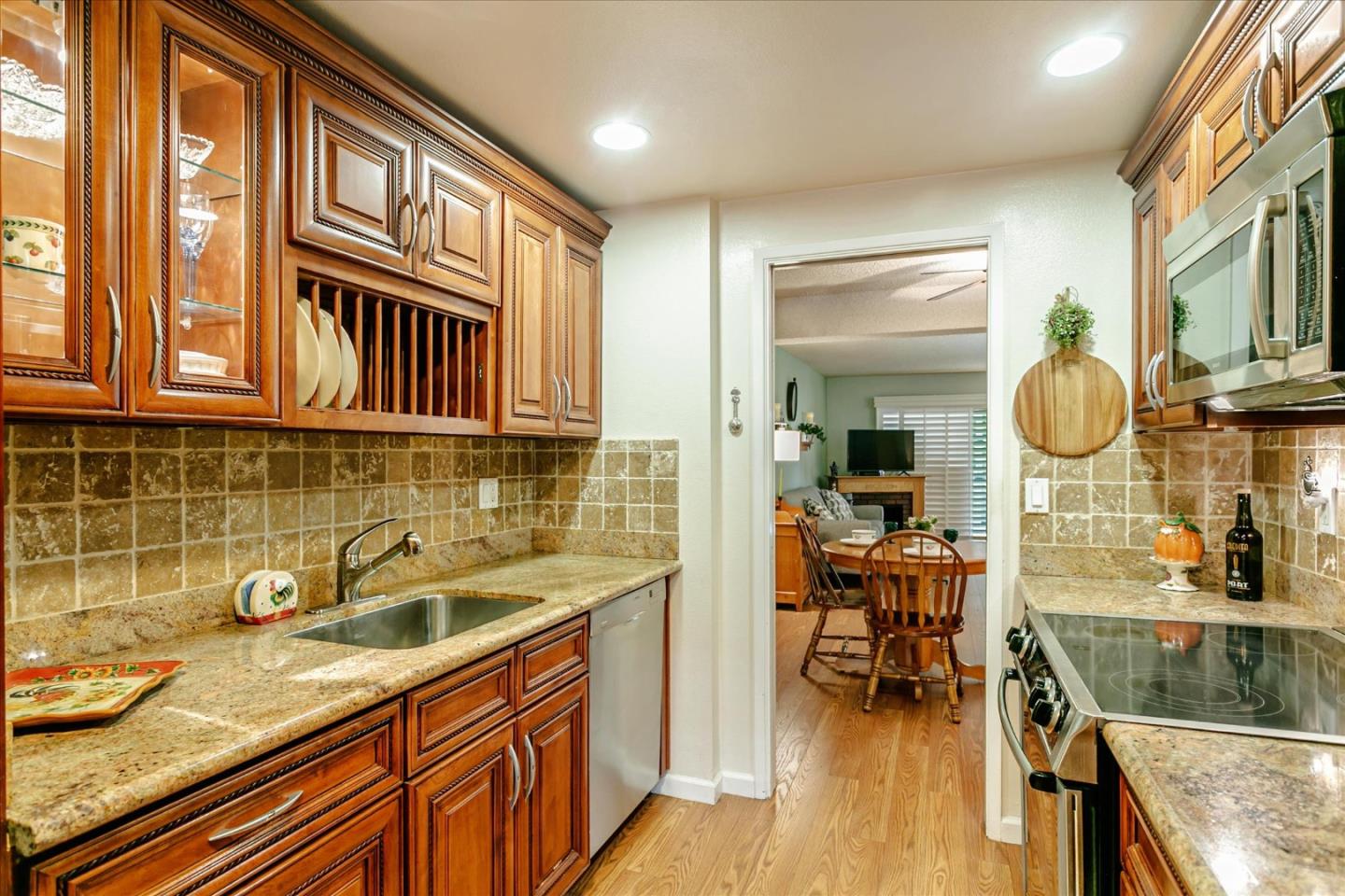 a kitchen with granite countertop a sink a stove and cabinets