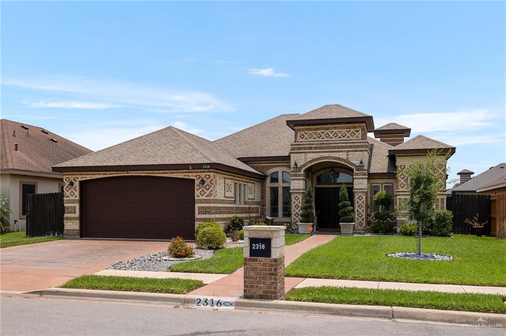 a front view of a house with a garden and garage