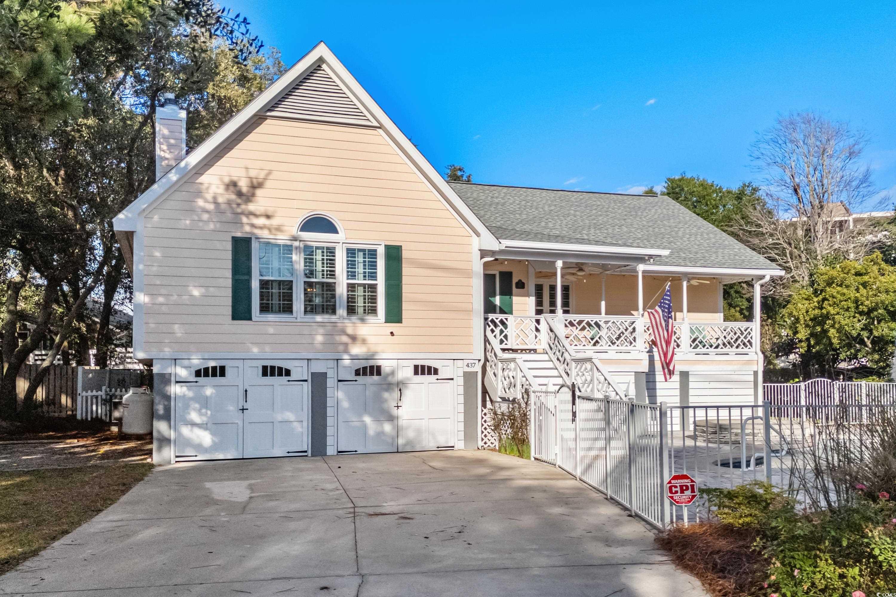 View of front of house featuring a porch and a gar