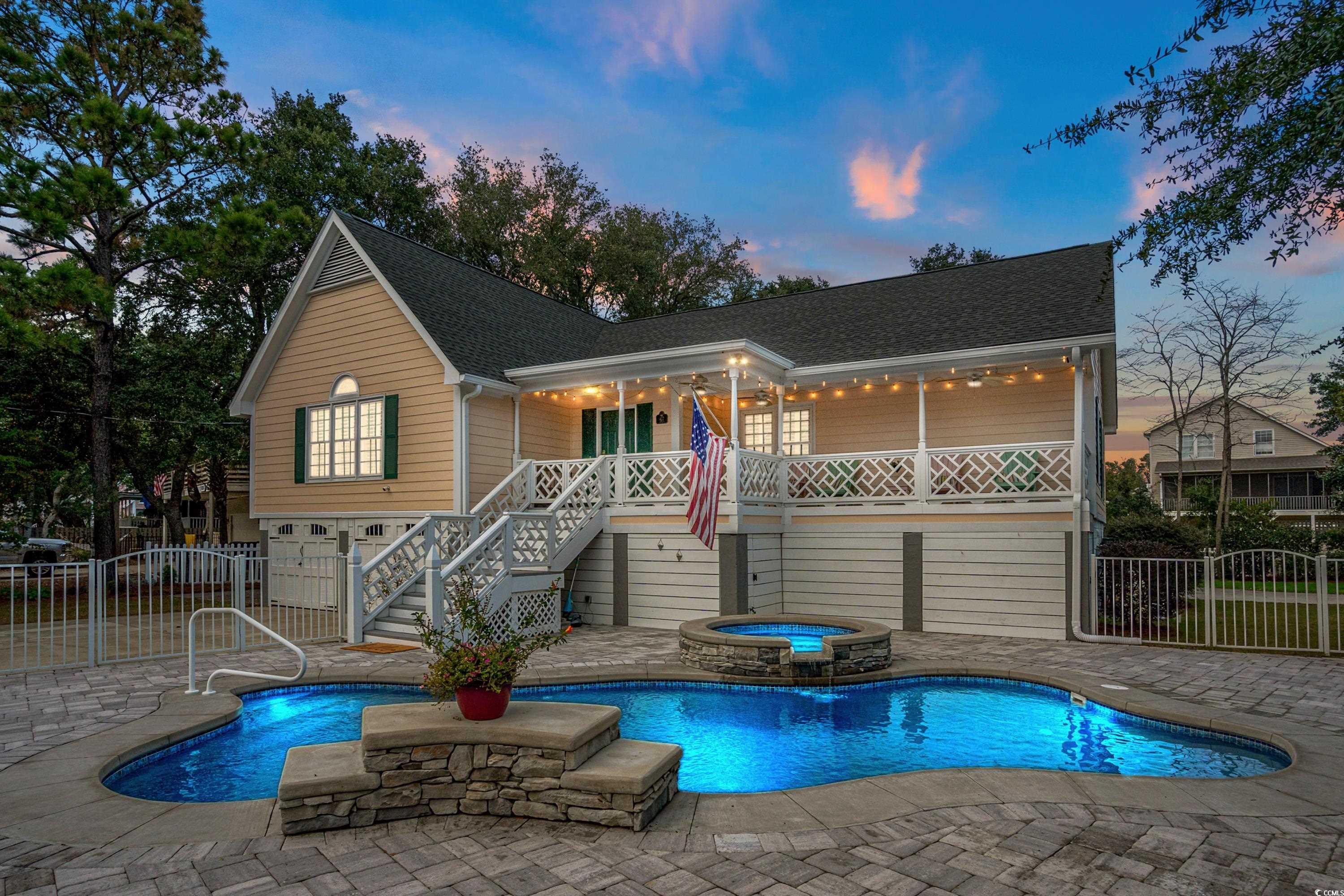 Back house at dusk with a swimming pool with hot t