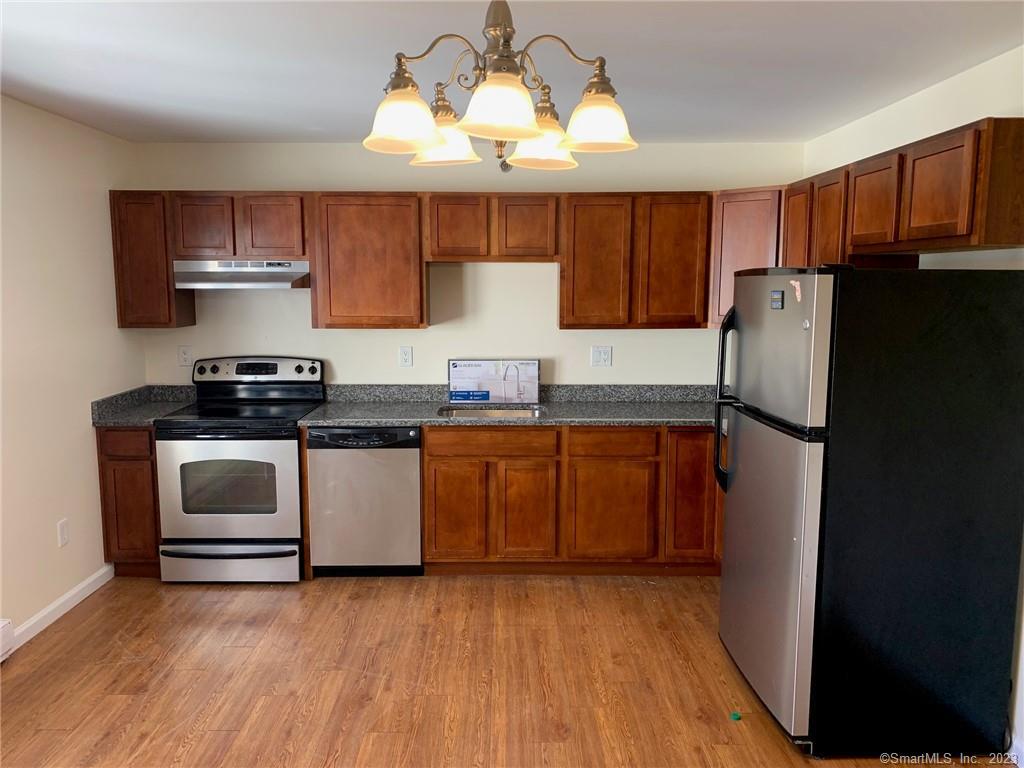 a kitchen with a refrigerator and a stove top oven