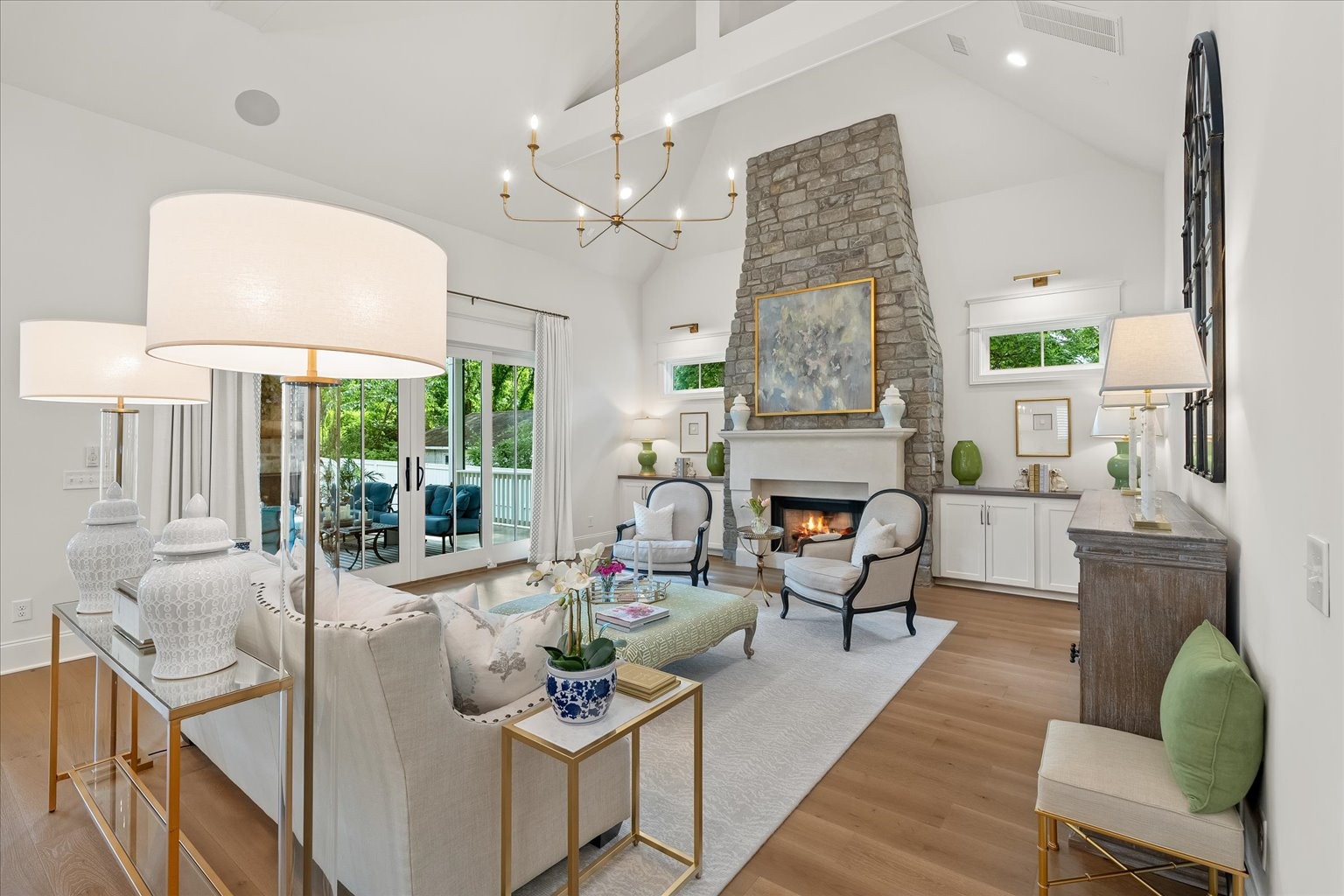 a living room with furniture a fireplace and a chandelier