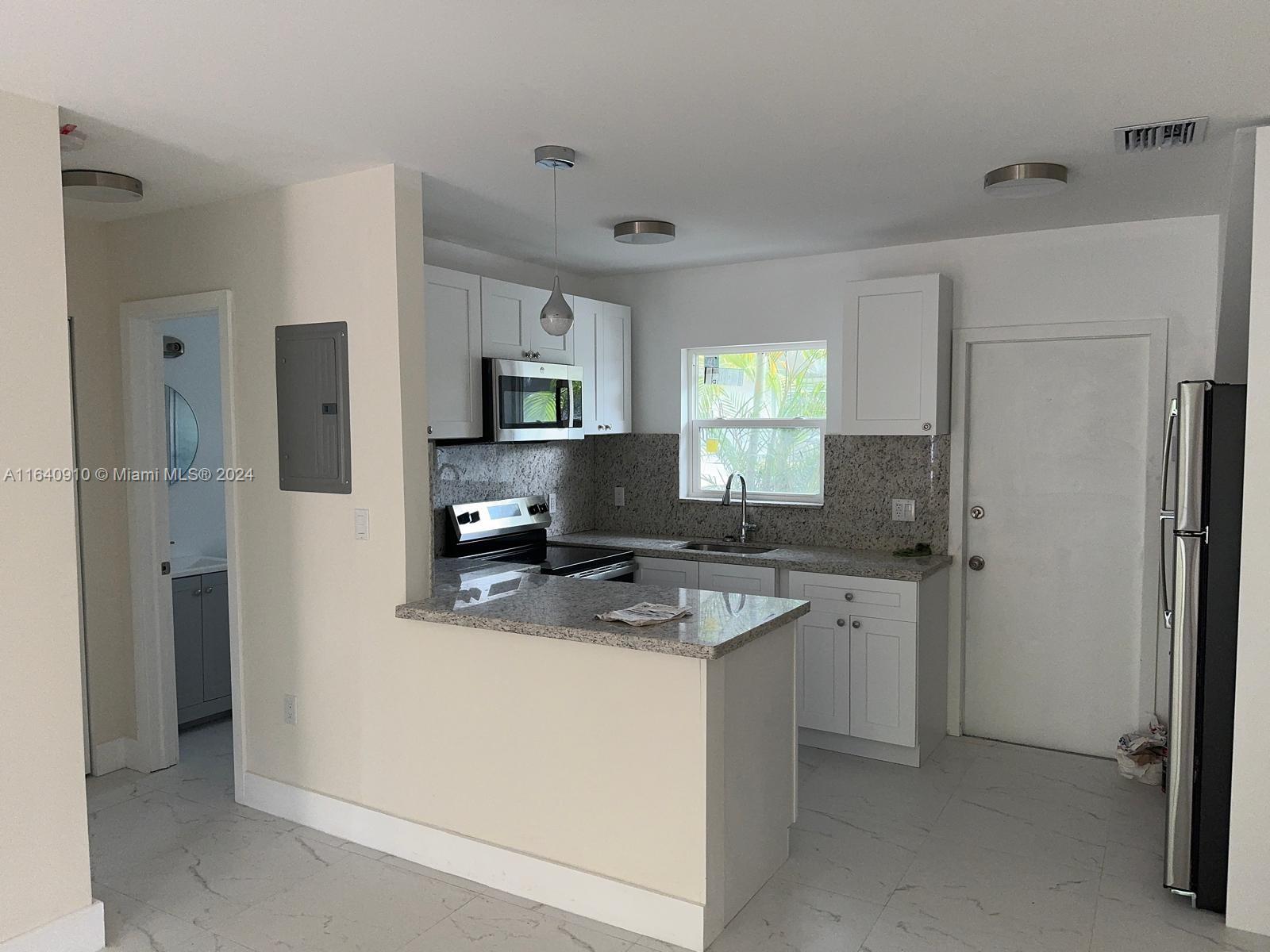 a kitchen with stainless steel appliances granite countertop a refrigerator stove and sink