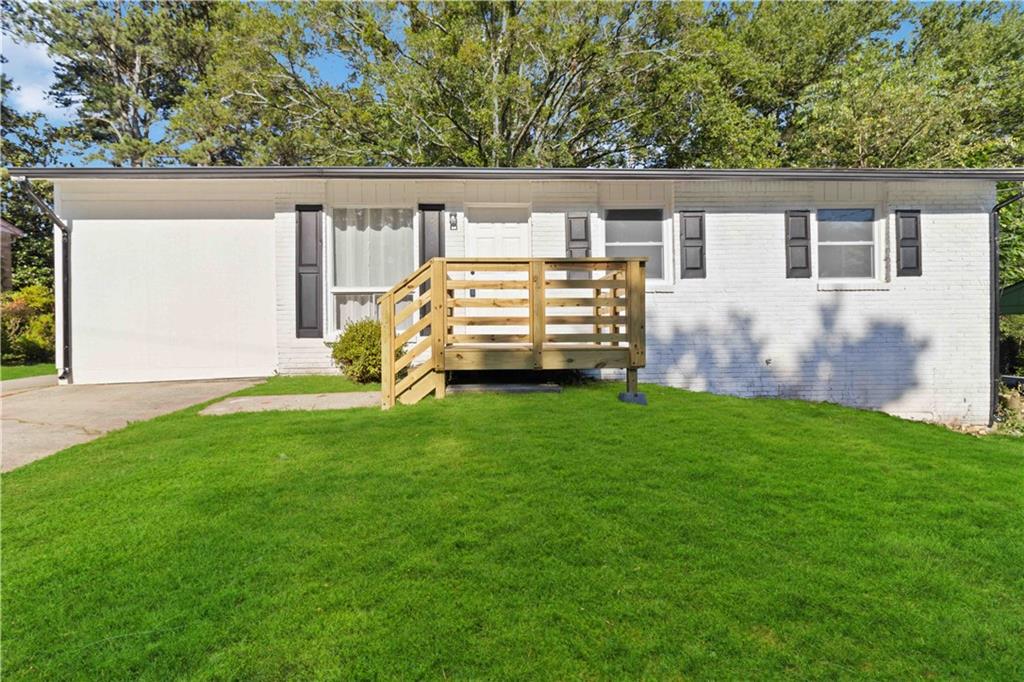 a view of house with backyard and deck