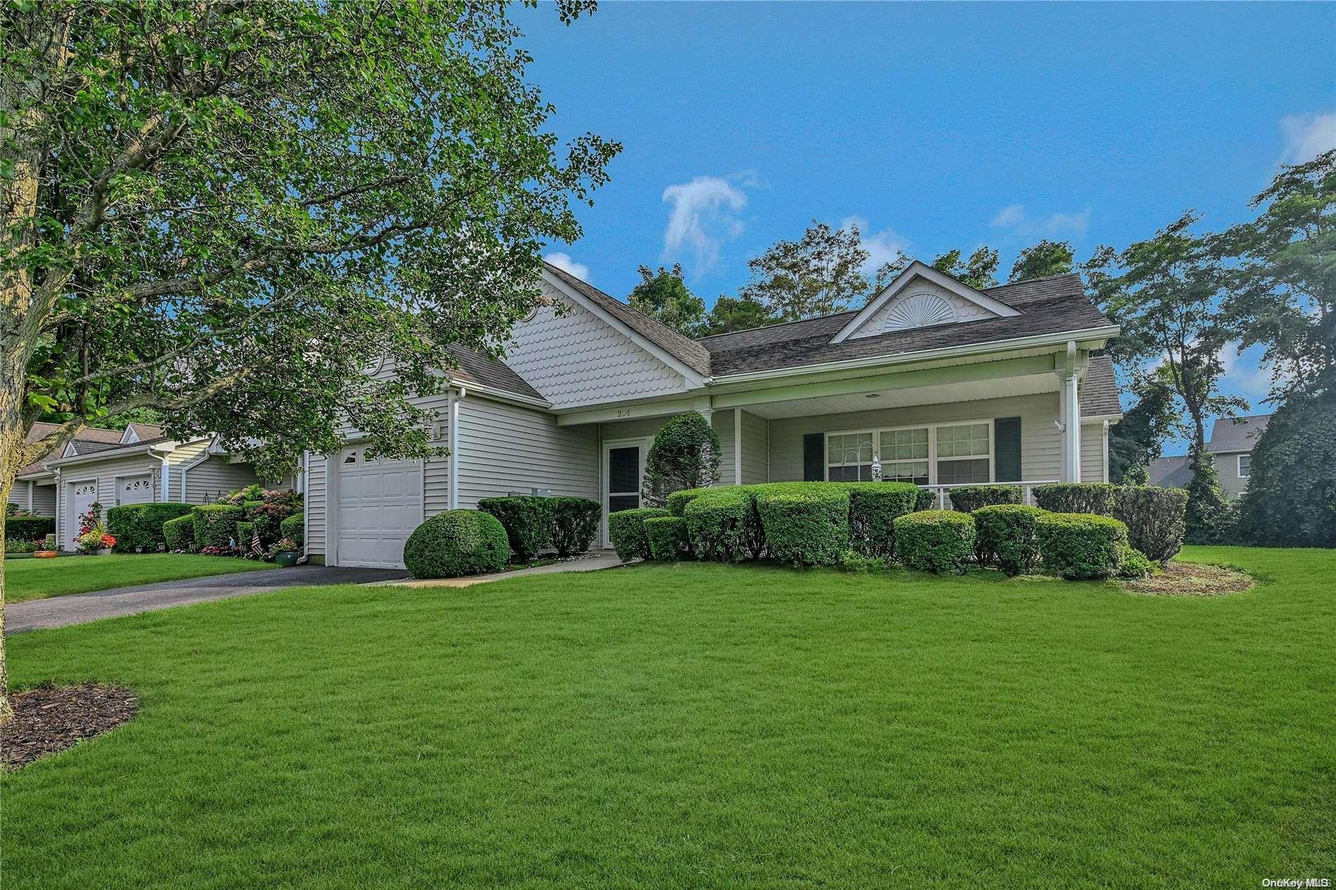 a view of a house with a big yard potted plants and large trees