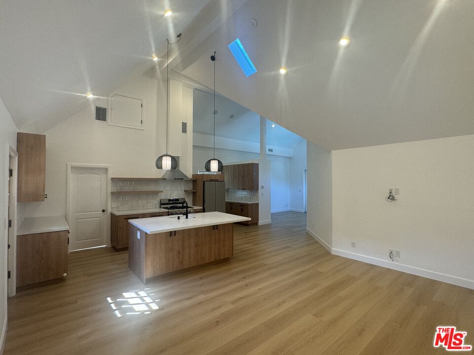 a kitchen with kitchen island a stove a sink and a refrigerator