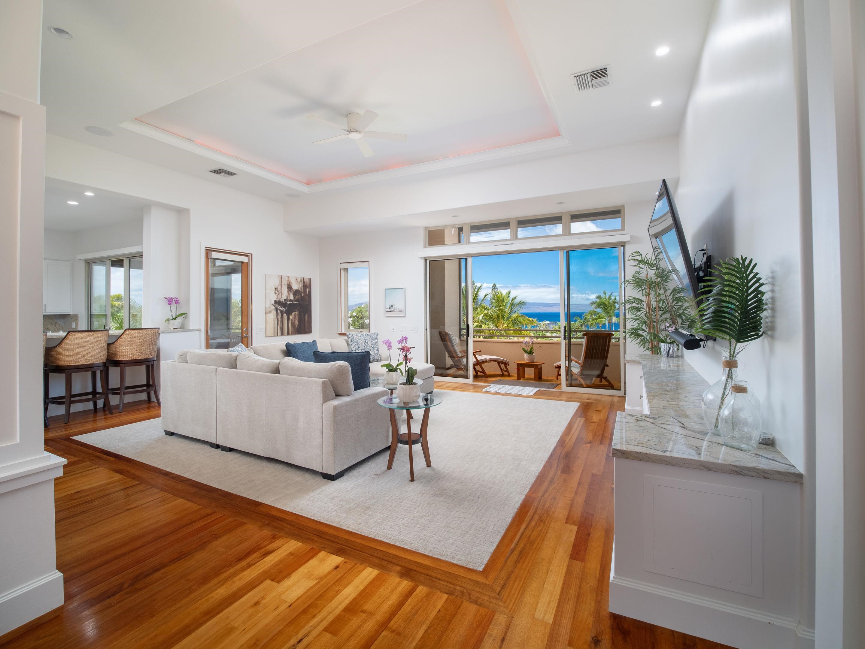 a living room with furniture large windows and wooden floor