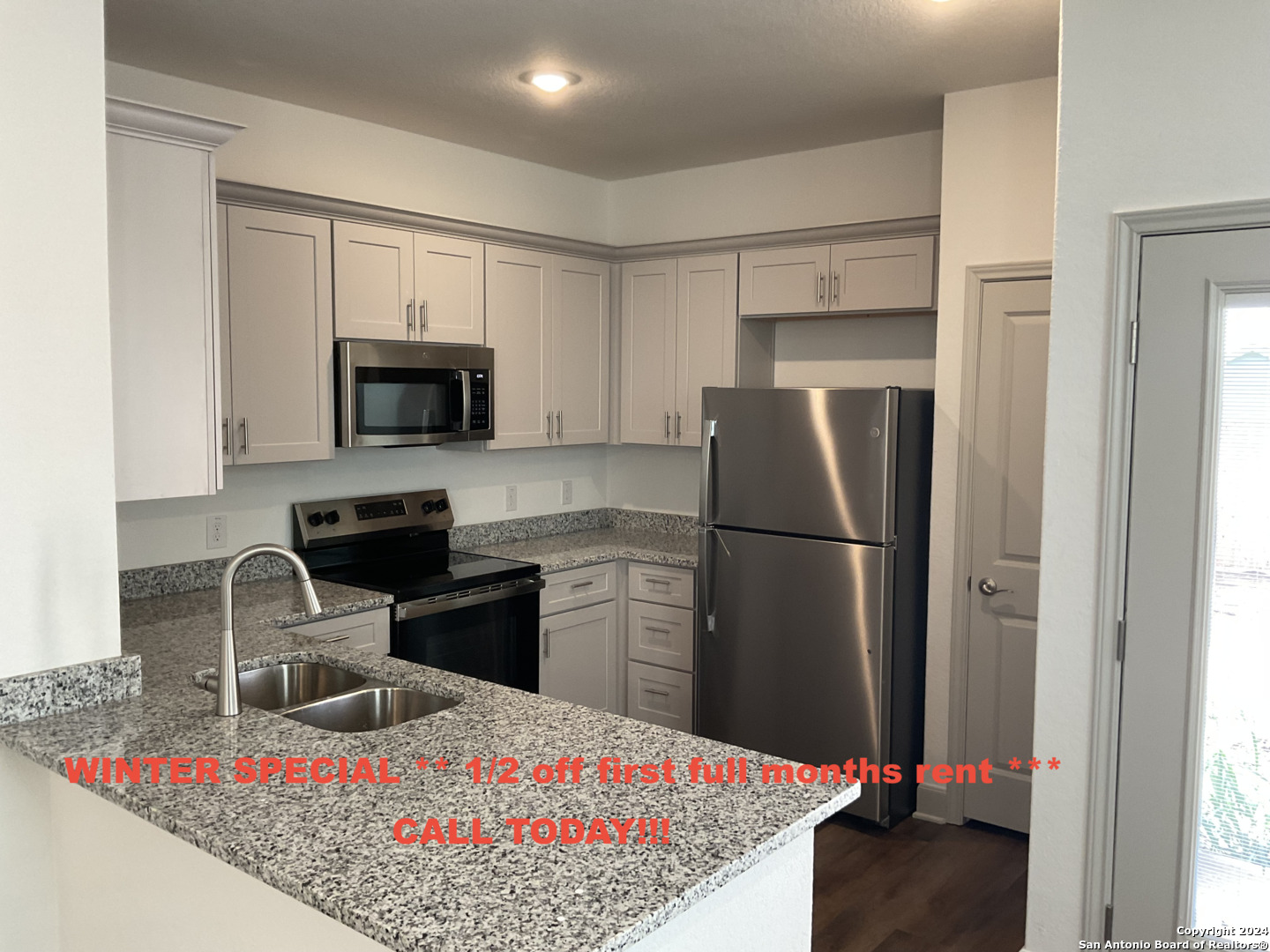 a kitchen with a refrigerator sink and wooden cabinets