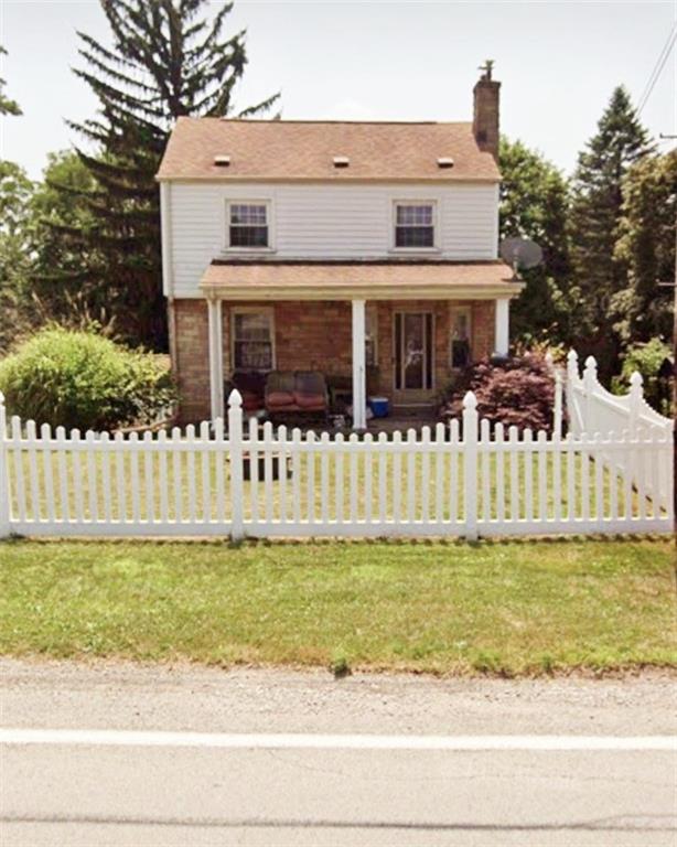 a front view of a house with a yard with plants and garage