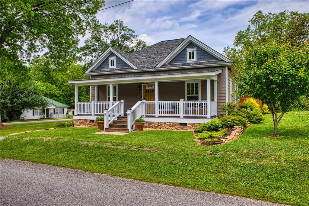 a front view of house with a garden and trees