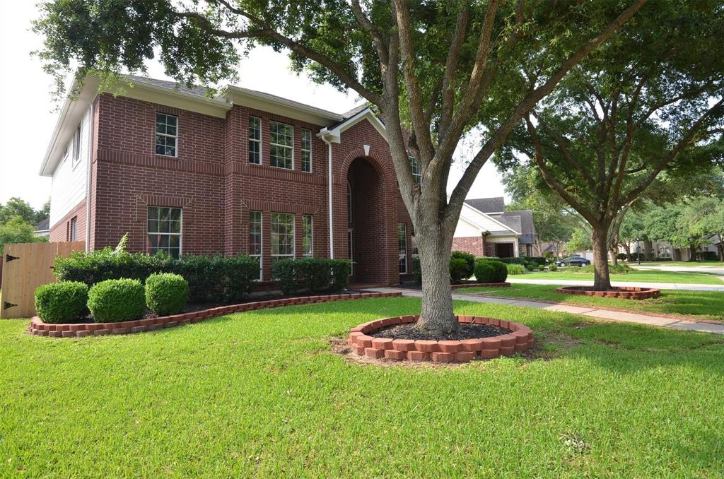 a front view of a house with a yard and fountain