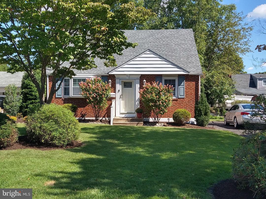 a front view of a house with a garden and trees