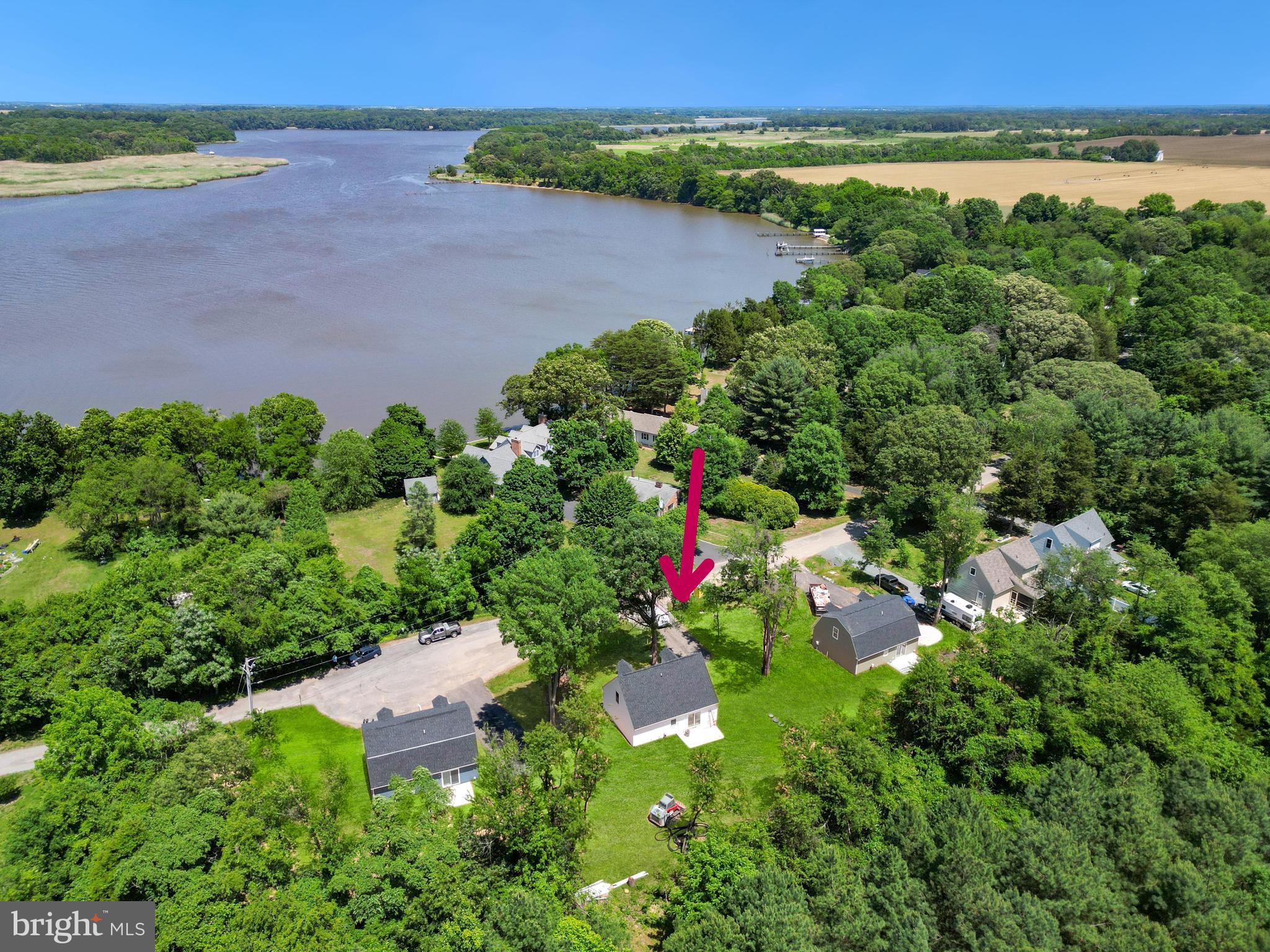 an aerial view of a houses with a yard and lake view