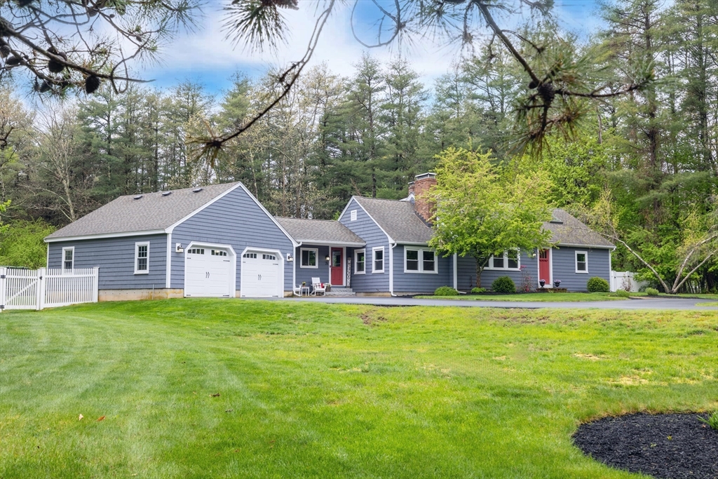 a front view of a house with a garden and trees