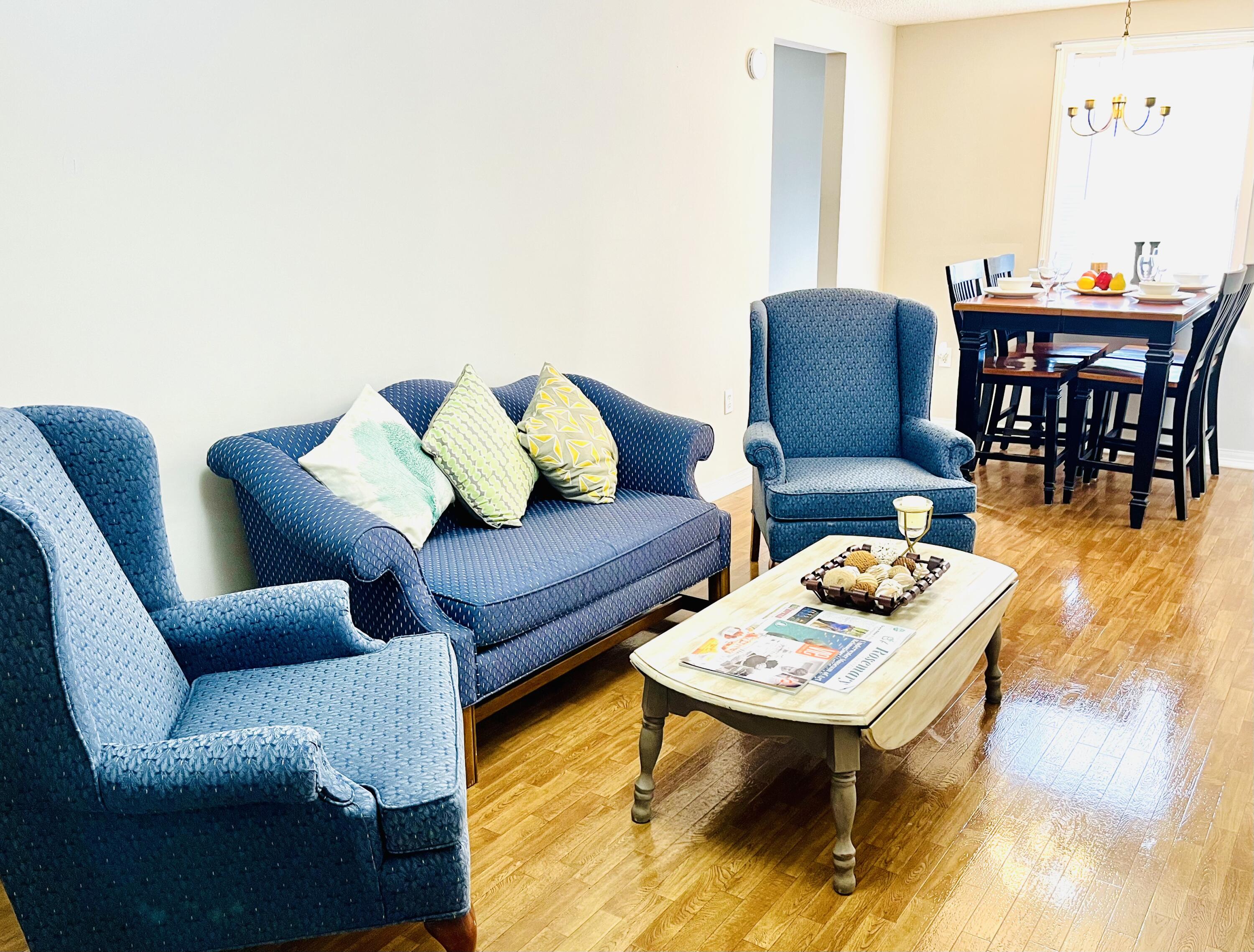 a living room with furniture a rug and a dining table