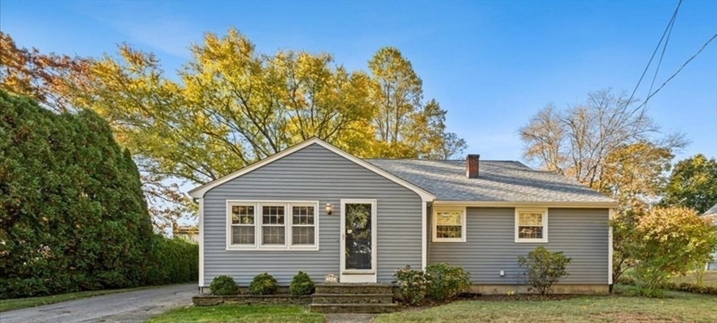 a front view of a house with a tree