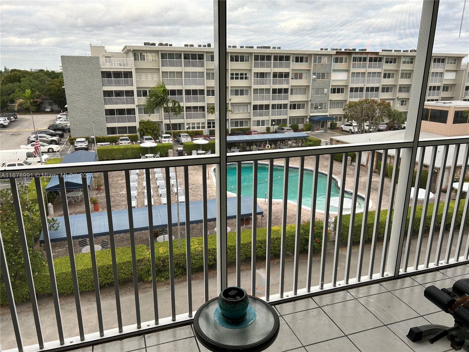 a view of a balcony with a floor to ceiling window next to a tall building