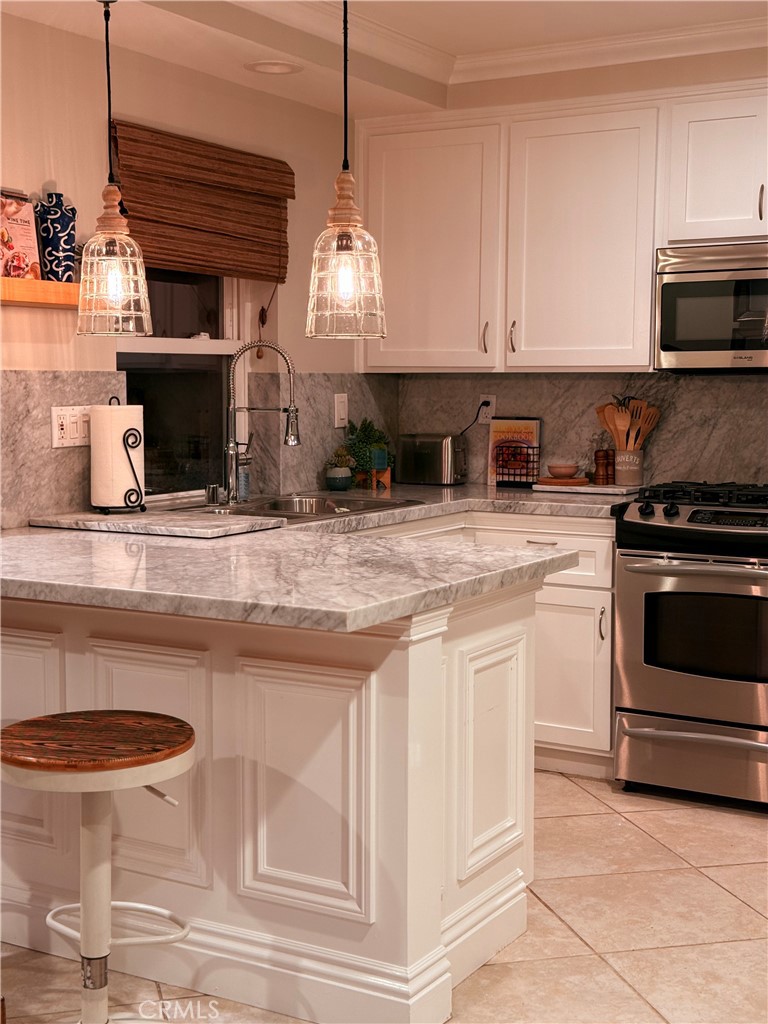 a kitchen with stainless steel appliances granite countertop a stove a sink and a white cabinets