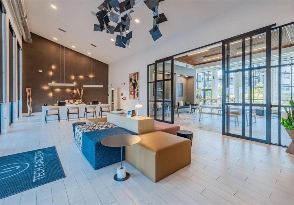 a living room with couches a coffee table and kitchen view with wooden floor