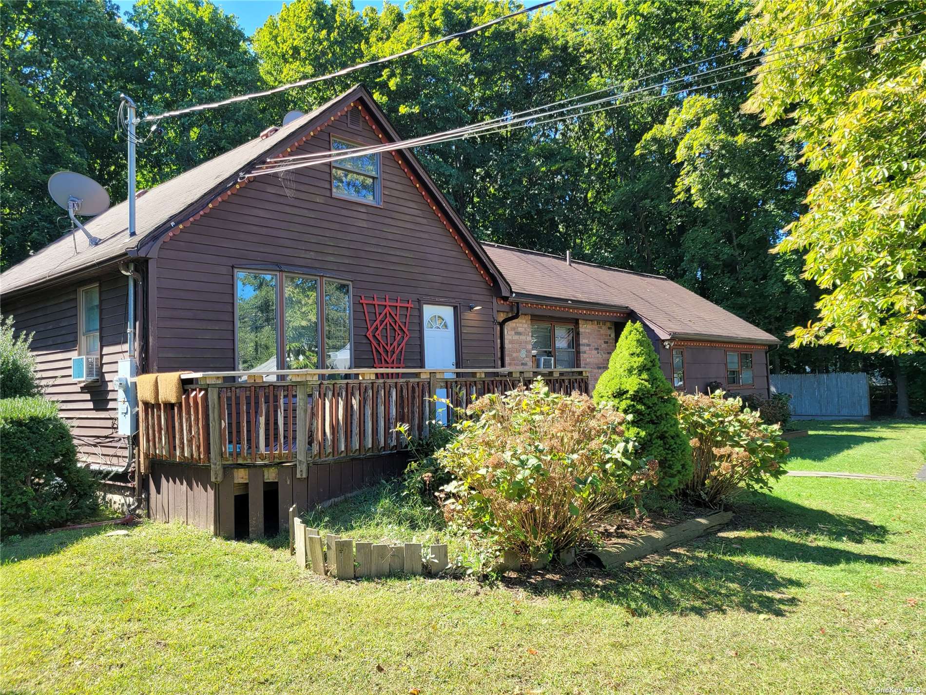 a view of a house with wooden deck front of house