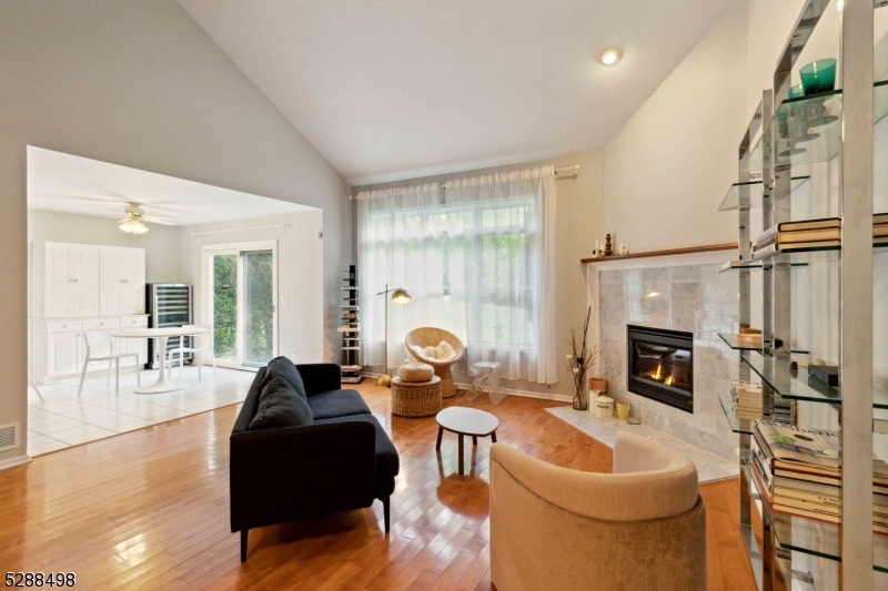 a living room with furniture a fireplace and a floor to ceiling window