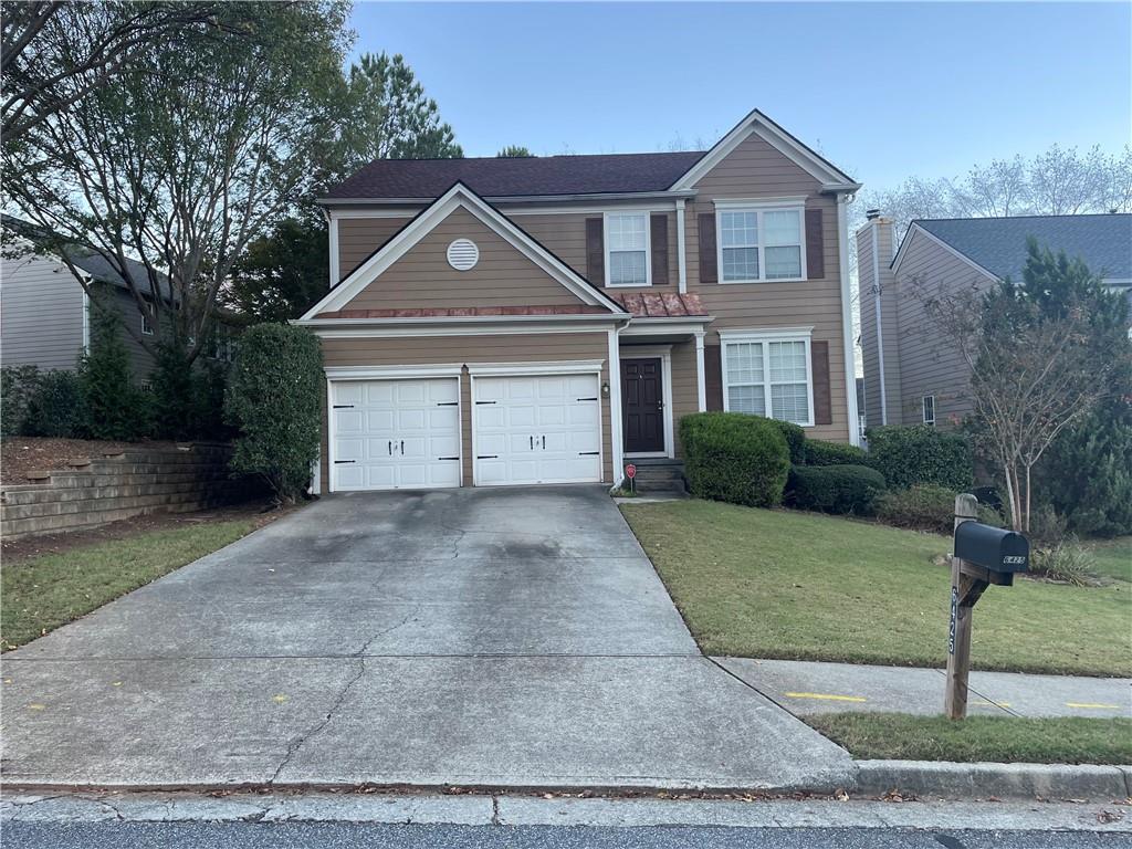 a front view of a house with a yard and garage