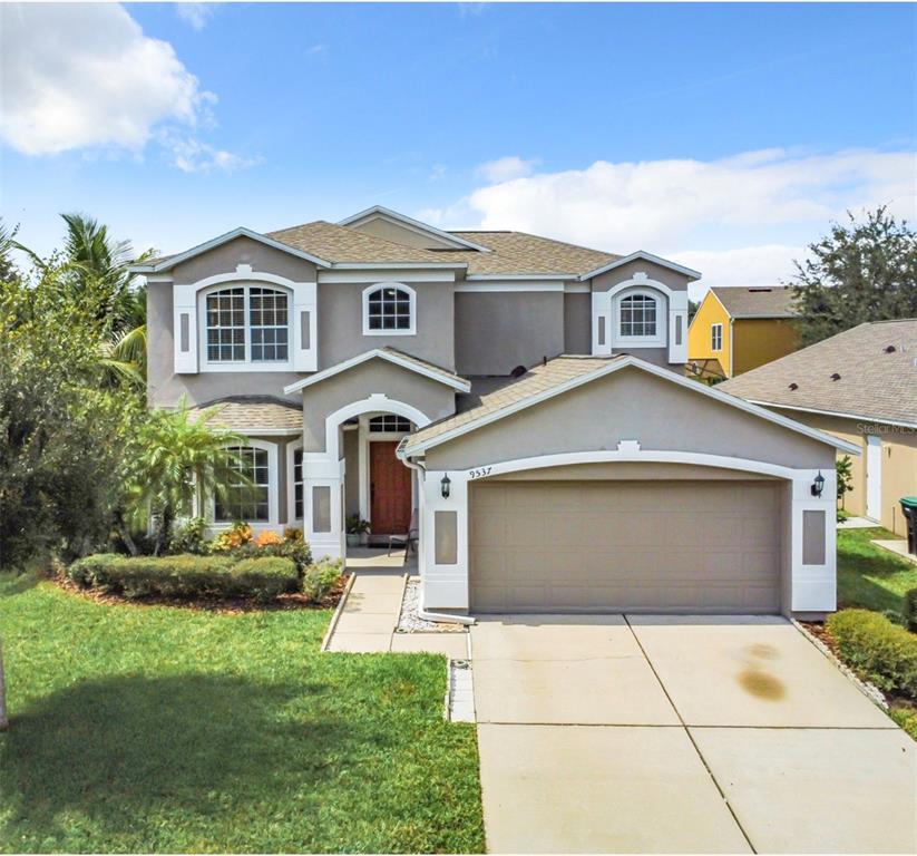 a front view of a house with a yard and garage