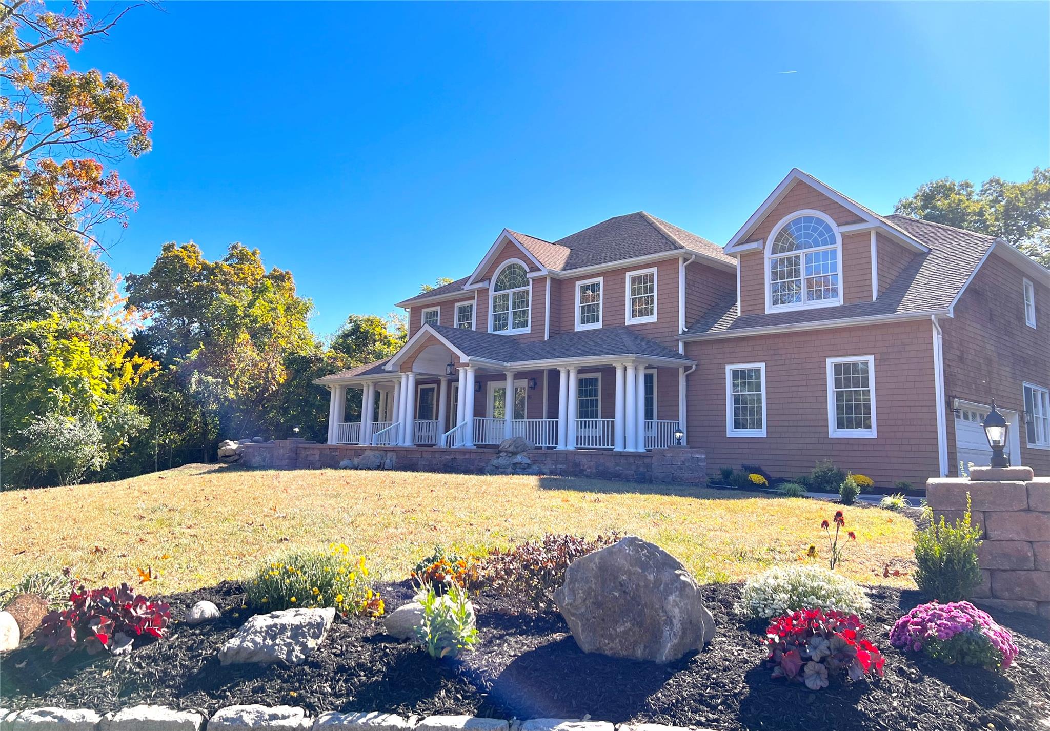 Colonial home with a front yard and a garage