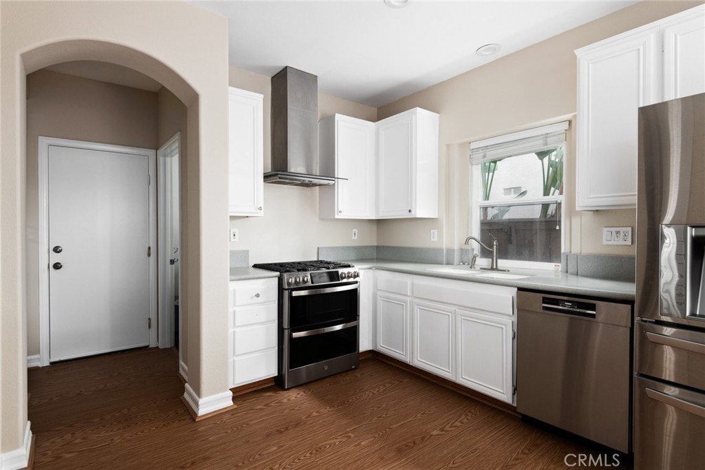 a kitchen with stainless steel appliances granite countertop a stove a refrigerator and a sink